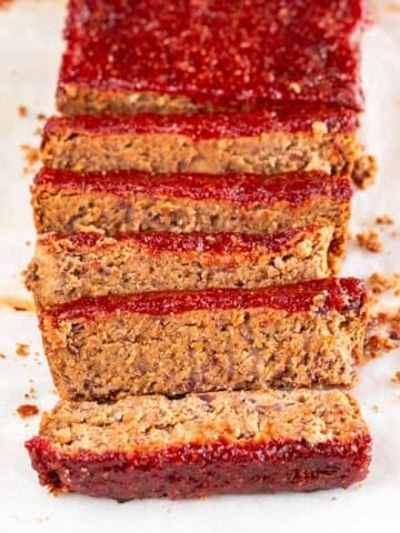 Sliced vegan meatloaf against a white backdrop.